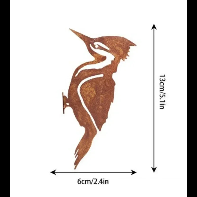 A silhouette of a bird in flight made from rustic wrought iron, used as a Halloween fence ornament.