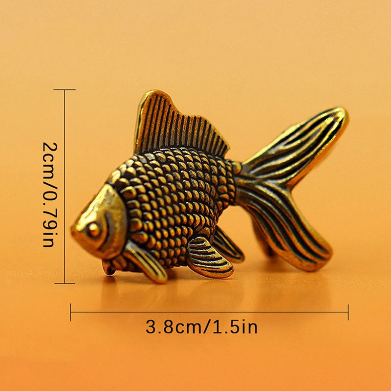 Retro brass goldfish statue with textured scales shown against an orange background.