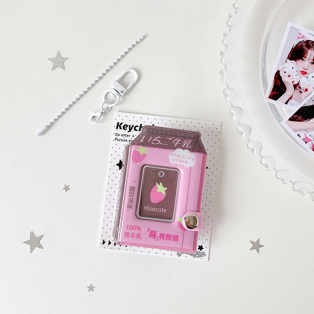 A pink plastic milk bottle photo keychain featuring a strawberry design and a small charm.