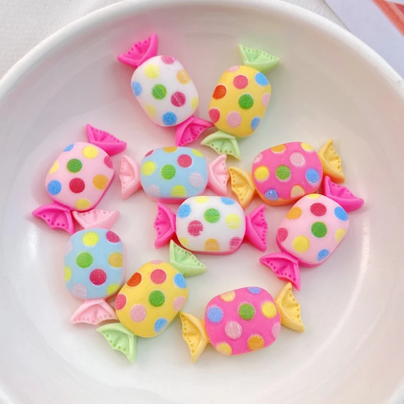 A collection of 20 colorful resin candy charms in various shapes and polka dots arranged on a white plate.