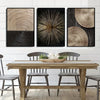 A set of three abstract canvas prints featuring concentric wood grain patterns in gold and black tones displayed above a wood