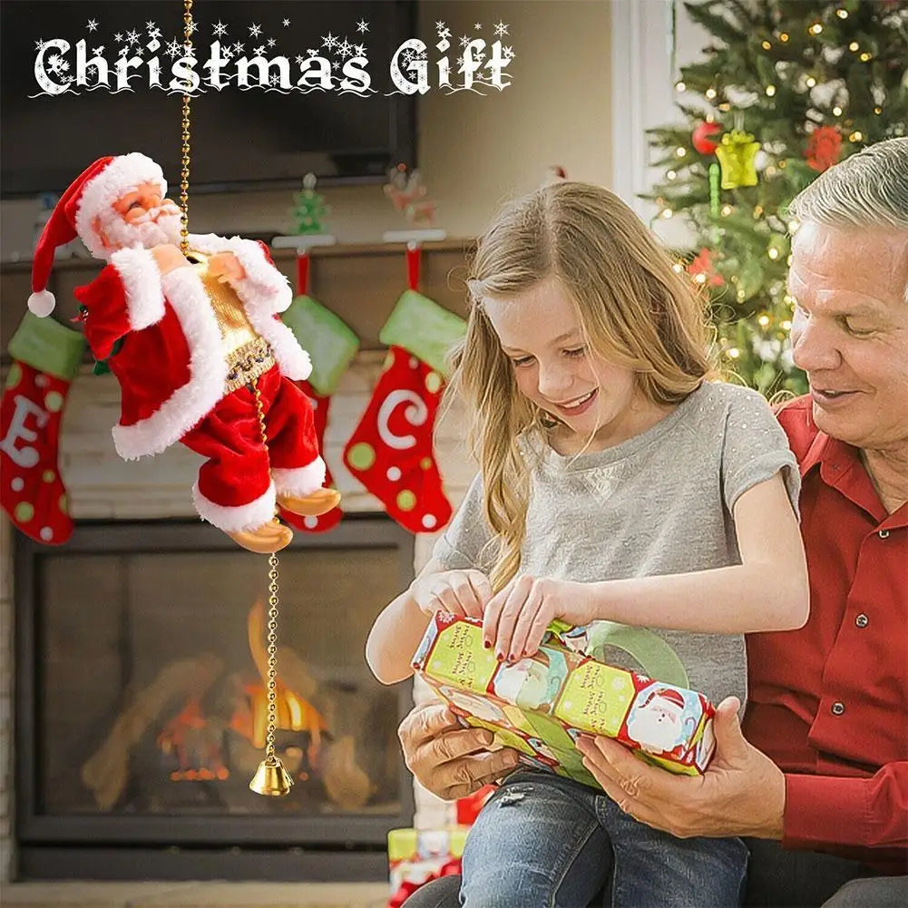 A young girl and man are looking at a climbing Santa Claus Christmas decoration with light-up features in a fireplace setting
