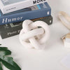 White hand carved wood knot used as coffee table decor resting on stacked books.