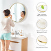 A woman looks into a large round vanity mirror with a matte metal frame, highlighting its high definition and explosion-proof