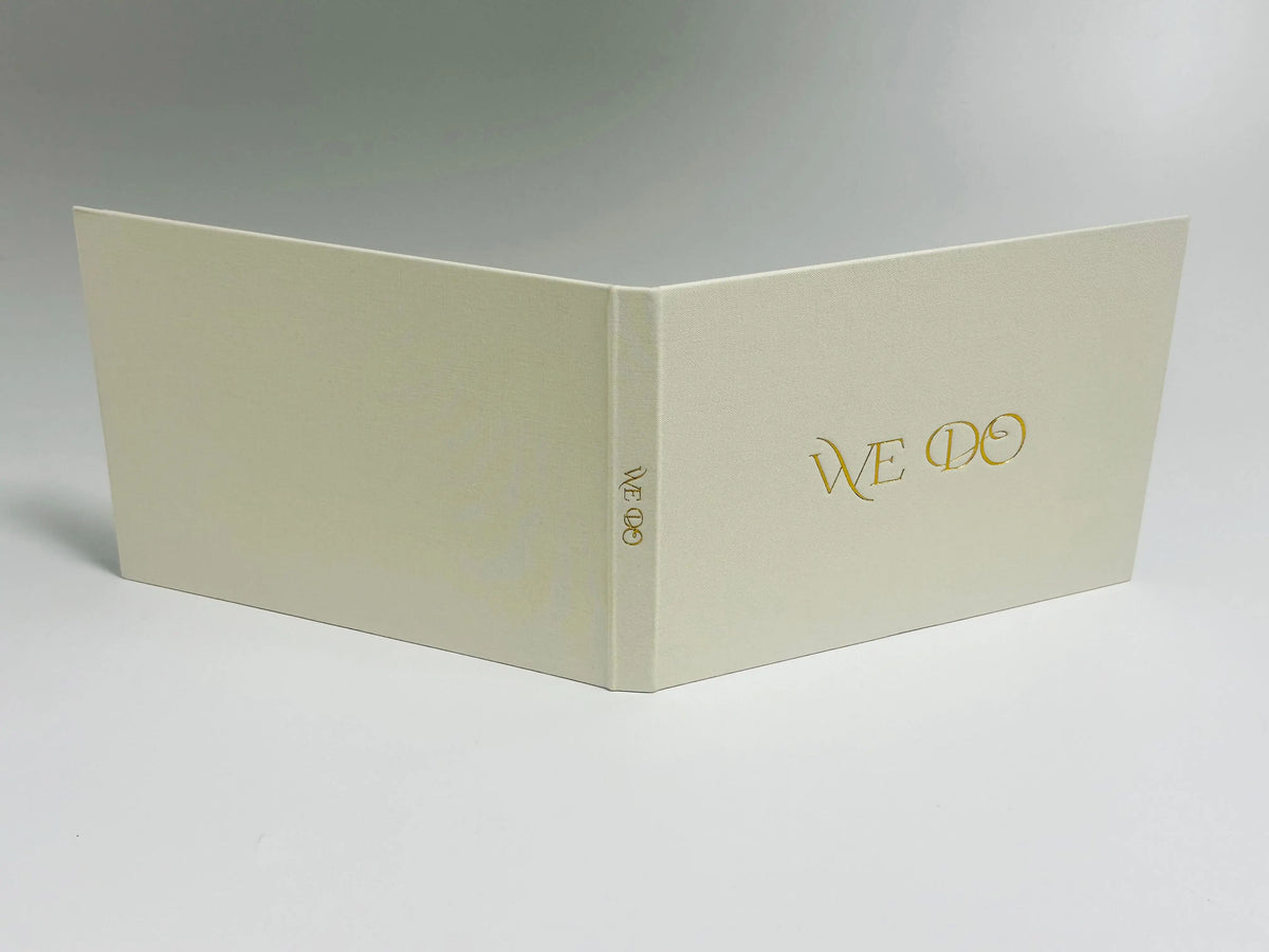 بطاقة من الكتان بلون البيج الفاتح ومطبوع عليها نصوص 'WE DO'، معروضة من زاوية.