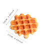 A golden brown waffle replica with a grid pattern, shown from above.