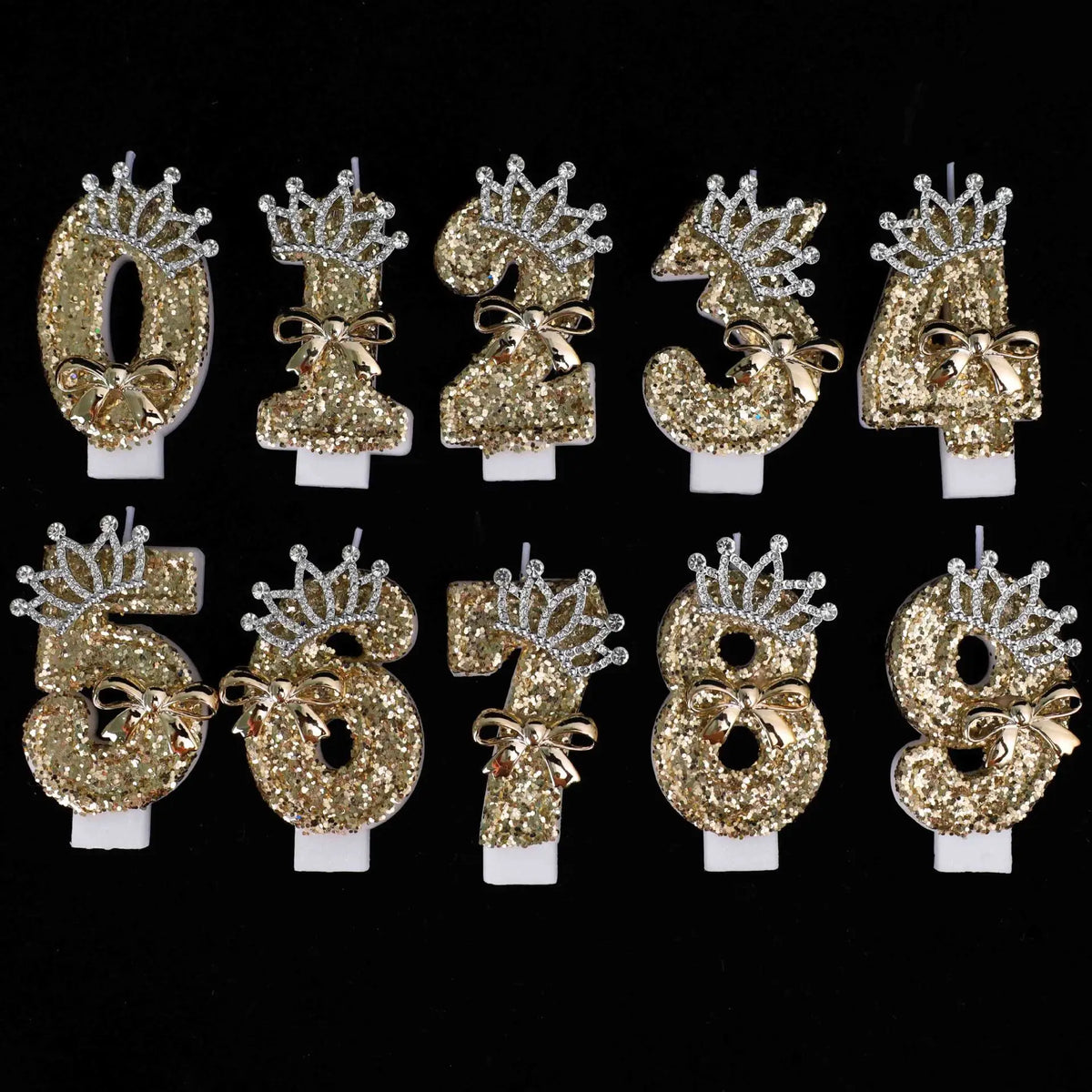 A set of gold glitter number cake toppers featuring rhinestone bows for the numbers 0 through 8.
