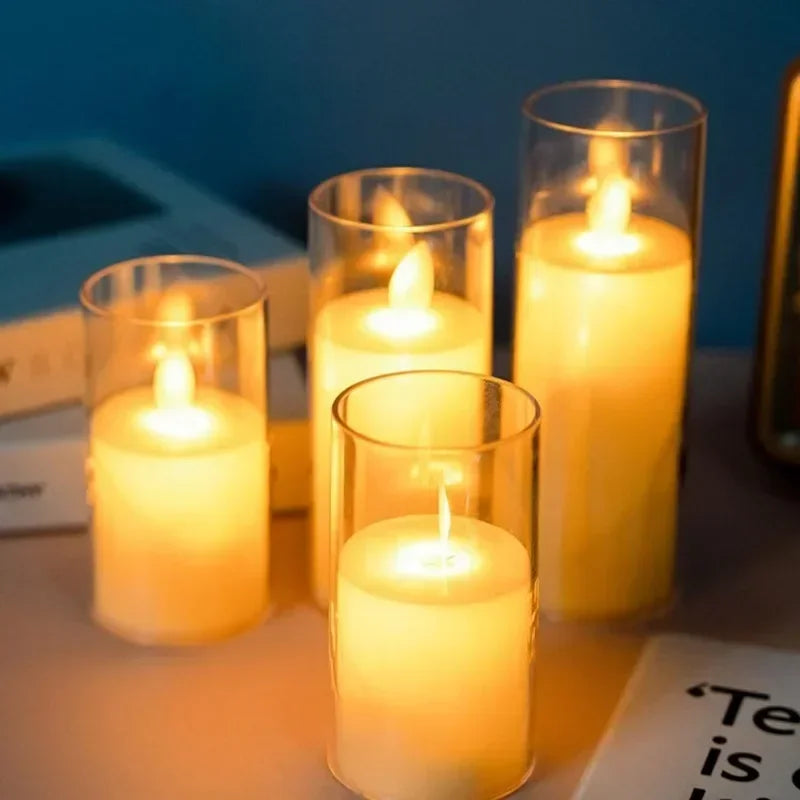 A collection of glowing yellow LED candles in glass holders with flickering flames on a white surface.