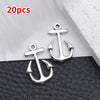A set of 20 silver vintage ship anchor charms displayed on a black surface.