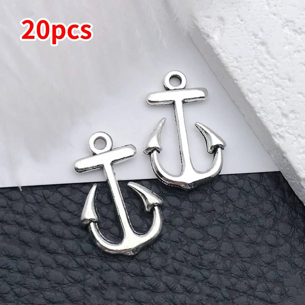 A set of 20 silver vintage ship anchor charms displayed on a black surface.
