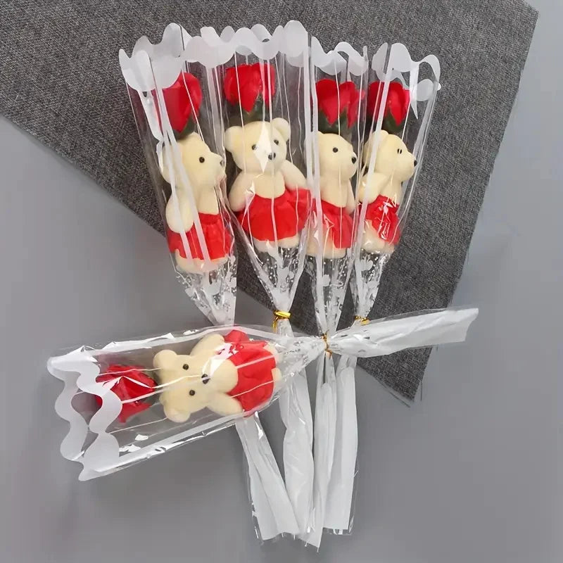 A bouquet of artificial red roses shaped like teddy bears wrapped in clear cellophane
