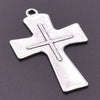 A silver antique cross charm with a bail, displayed against a dark gray background.