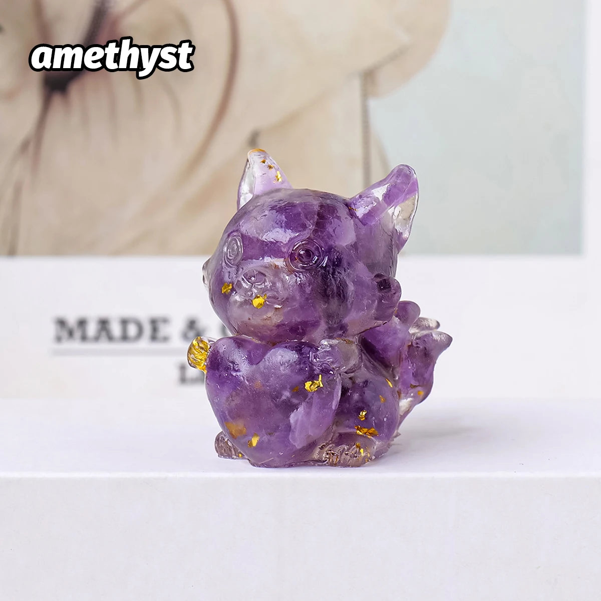 A small, purple amethyst crystal sculpture shaped like a fox, decorated with gold accents.