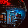 A LEGO Death Star model illuminated with blue LED lighting against a dark background.