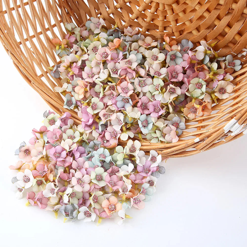 A pile of pink and white silk artificial flower heads in a woven basket for crafts and decor