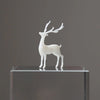 A white resin ornament of an elk deer with antlers displayed on a clear glass pedestal.