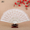 A white lace folding hand fan with a decorative base is displayed against a background of red blossoms.