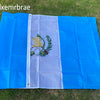 A blue and white flag displayed outdoors on green grass.