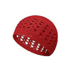 A close-up view of a handmade red crochet beanie hat with an open lace pattern.
