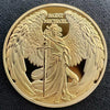 A gold-colored coin featuring a relief sculpture of Saint Michael with outstretched wings and holding a staff.