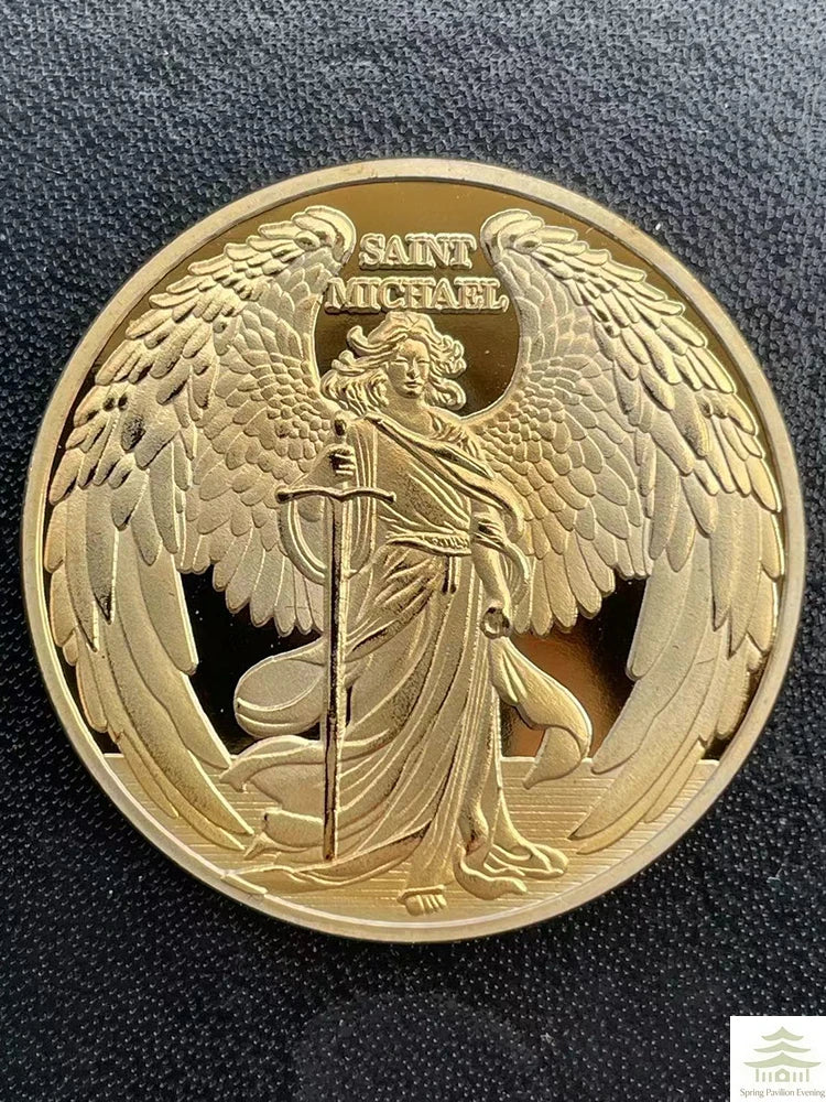 A gold-colored coin featuring a relief sculpture of Saint Michael with outstretched wings and holding a staff.