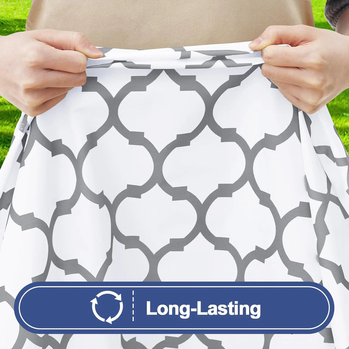 Hands adjusting a white patterned tablecloth with a gray geometric design for a folding table.