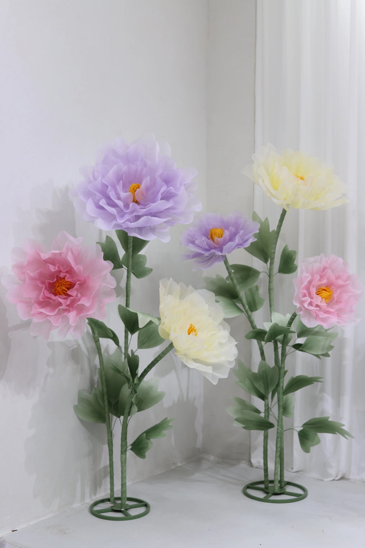 Large artificial silk purple and yellow poppy flowers displayed on green stands