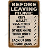 A vintage brown tin sign listing items to take before leaving home, including keys, wallet, cell phone, knives, and guns.