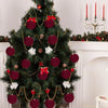 A decorated Christmas tree adorned with velvet flocked ornaments in shades of deep red and green.