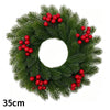 Green artificial Christmas wreath decorated with red berries and a velvet bow