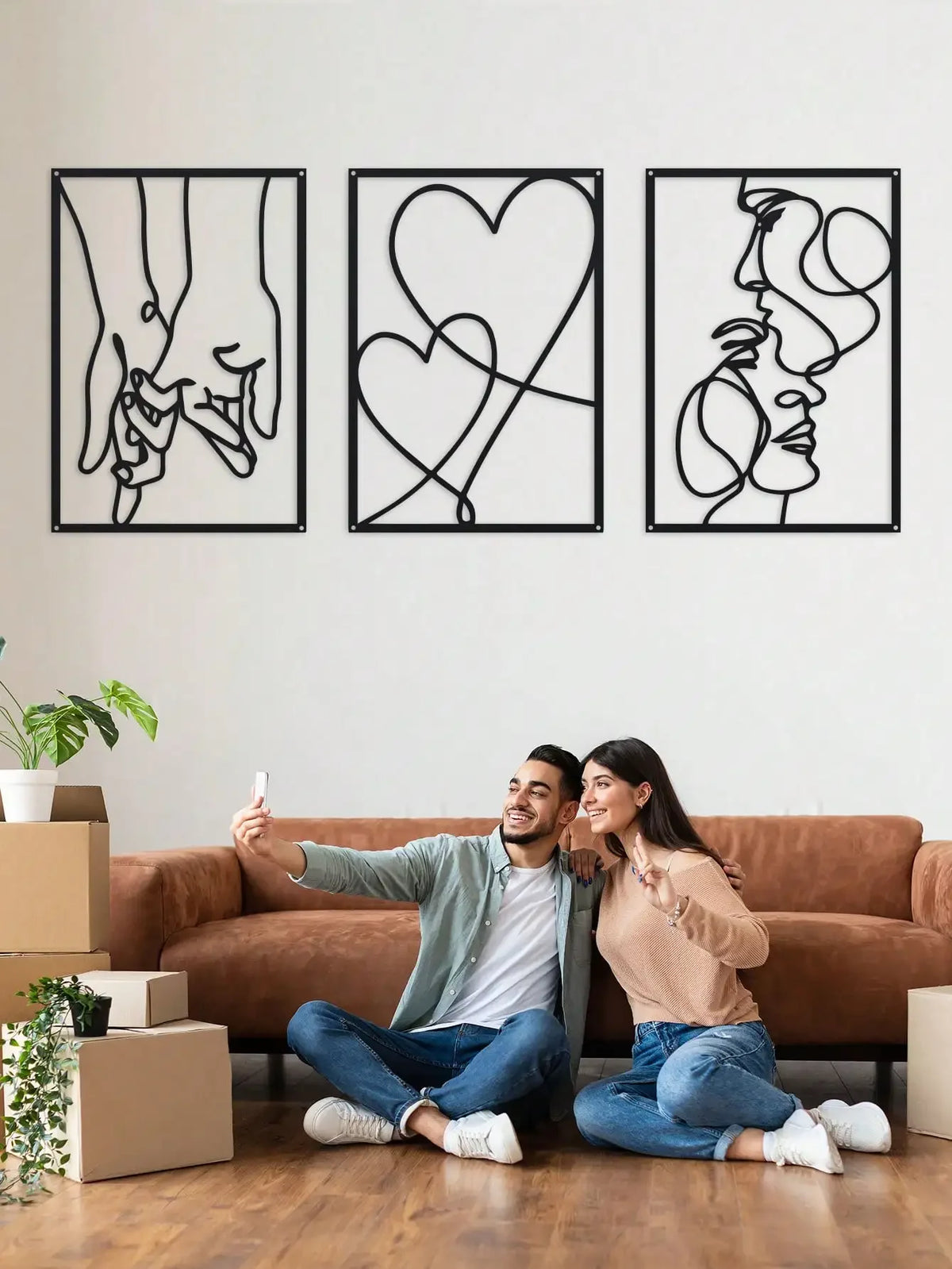 Three framed black line art prints depicting hands holding, a heart, and a profile of a face.