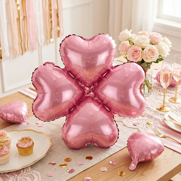 A set of ten pink heart-shaped foil balloons arranged on a wooden surface with floral decor.