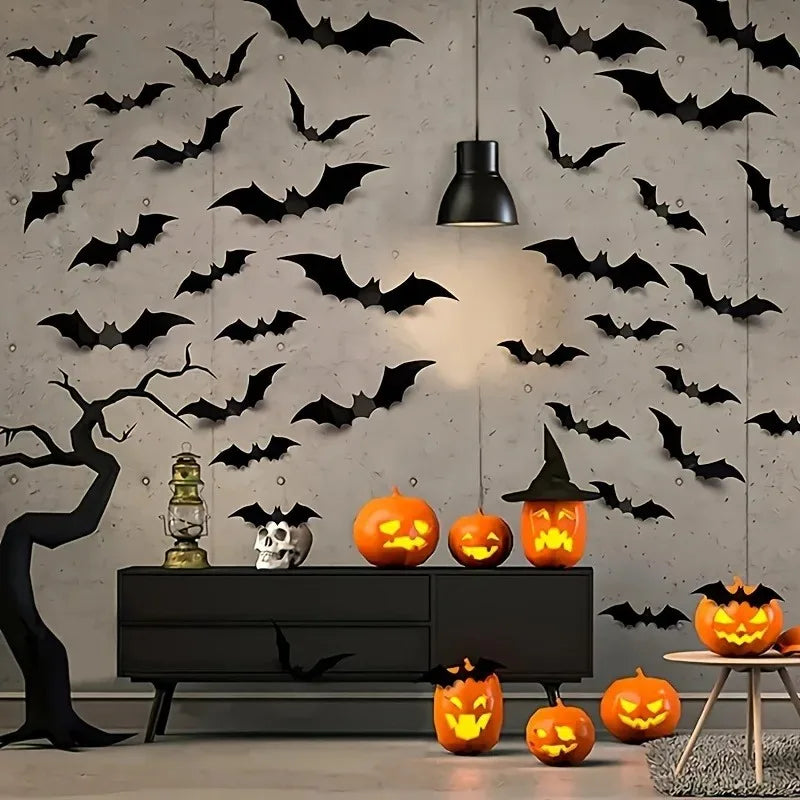A dark gray wall decorated with black bat silhouettes and a black tree silhouette, featuring carved pumpkins.
