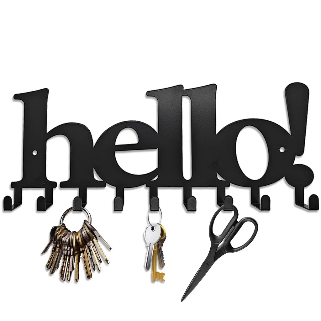 Black decorative metal wall-mounted key holder with seven hooks and a pair of scissors