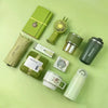 A green gift set featuring a tumbler, towel, and UPF sun protection item on a light green background.