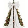 A Christmas tree decorated with gold and red ornaments and a large white bow and long streamers.