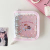 A clear plastic binder with a pink fabric cover and a glitter star design featuring a cat and a mouse.