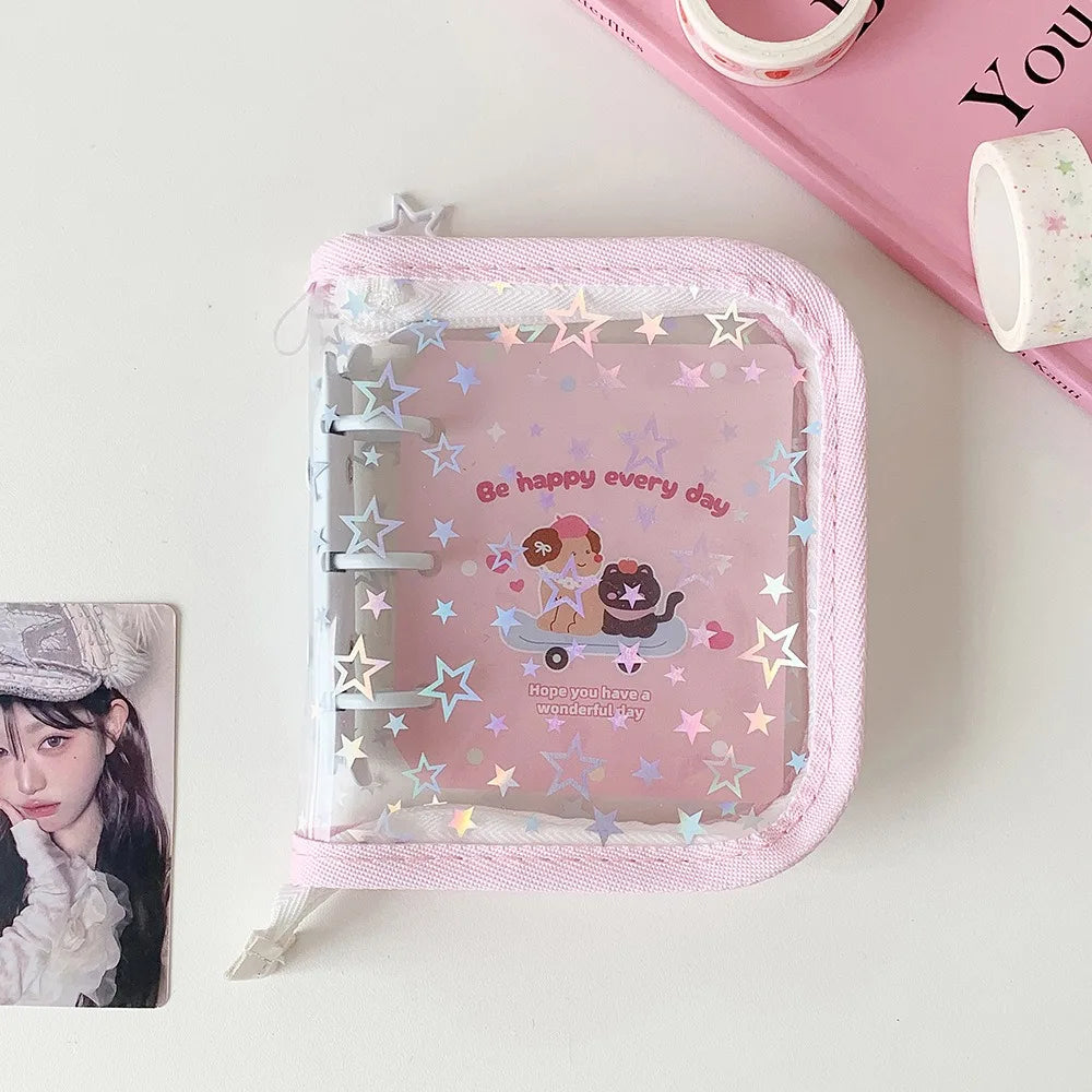 A clear plastic binder with a pink fabric cover and a glitter star design featuring a cat and a mouse.