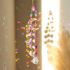 A hanging crystal sun and moon suncatcher featuring iridescent glass beads and charms.