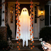 Decoración fantasma de tela blanca con hojas de arce colgando frente a una puerta.