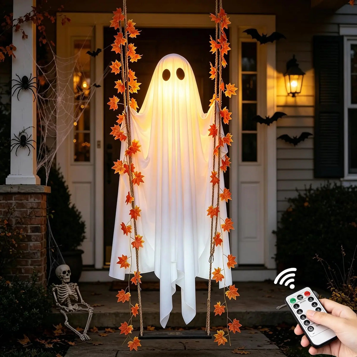 Decoración fantasma de tela blanca con hojas de arce colgando frente a una puerta.