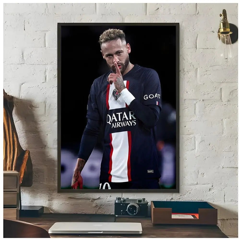 A framed poster of Neymar Jr in a dark shirt posing with his finger, displayed on a white brick wall.