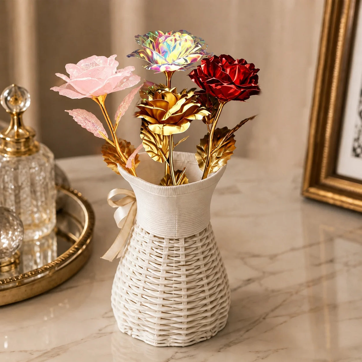 A bouquet of iridescent gold foil roses in various shades of pink and red displayed in a white woven vase.