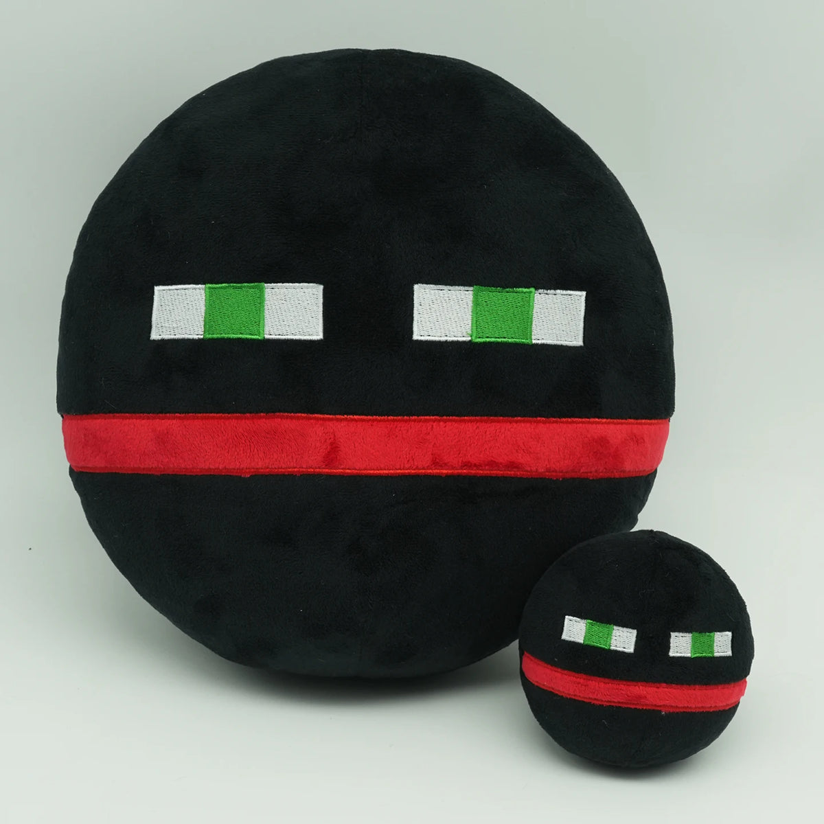 A black plush doll with white and green stripes on its face, resembling a horror game character.