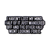 Black enamel pin with white text that reads I HAVEN'T LOST MY MIND HALF OF IT JUST WANDERED OFF AND THE OTHER HALF WENT LOOKI