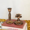 A vintage resin wall sconce candle holder with a golden frame and a terracotta-colored oil lamp design.