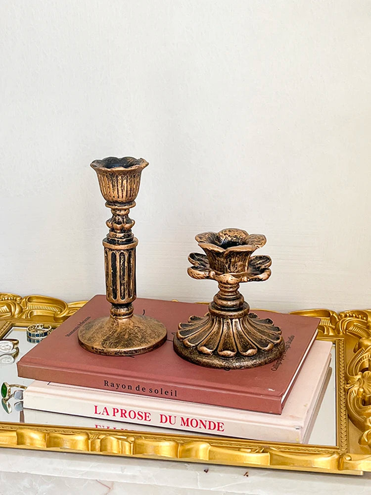 A vintage resin wall sconce candle holder with a golden frame and a terracotta-colored oil lamp design.