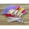 A fan of colorful silk wedding fans with bamboo frames arranged on a wooden surface.