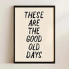 A framed print with black text that reads These are the good old days on a light beige background.