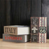 A stack of books titled Italy and London displayed in front of a dark wooden background.